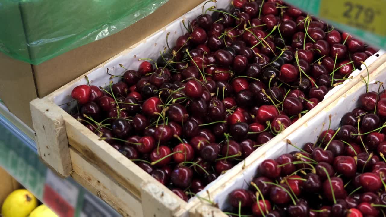 女人在商店或市场挑选樱桃浆果。素食和健康食品的销售理念视频素材