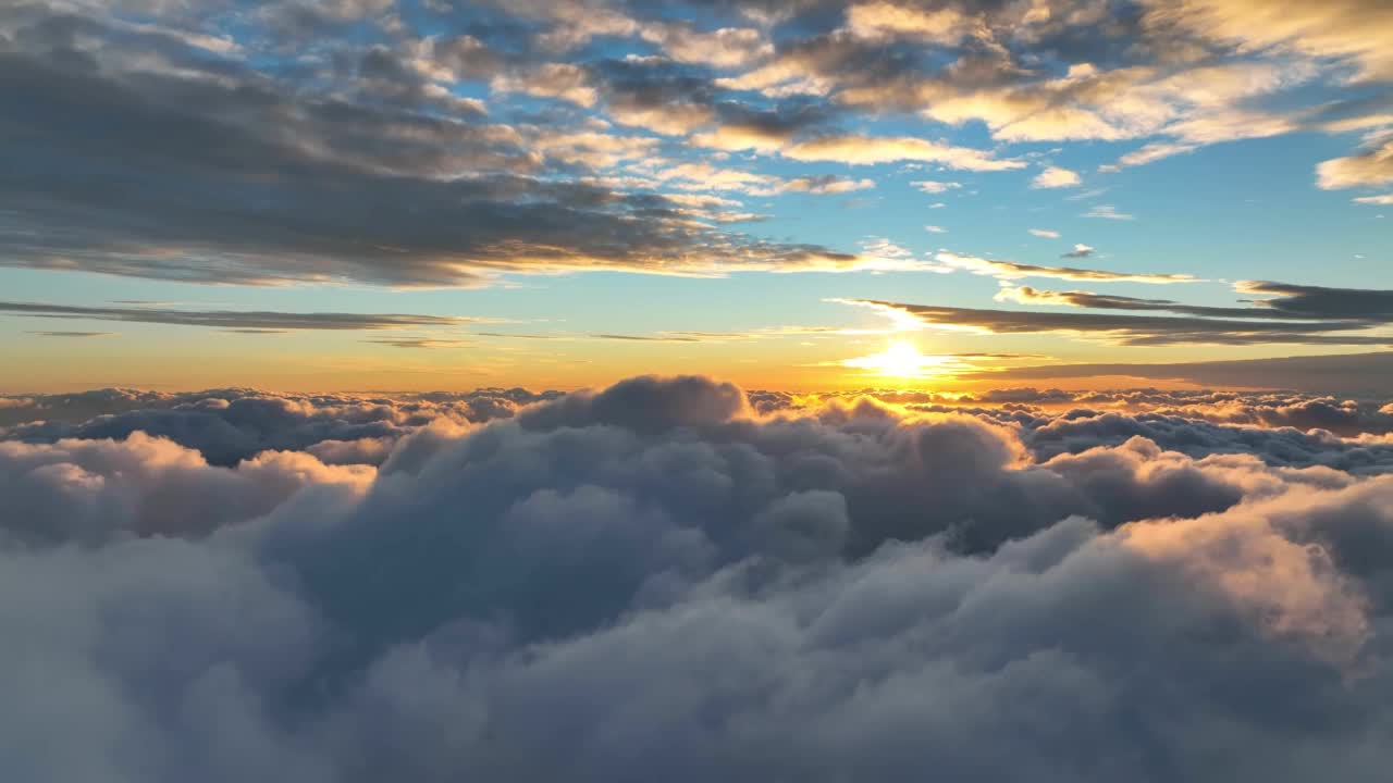 壮丽的日落在云层上方的空中超摄。在夕阳的光芒中飞过厚厚的云层视频素材