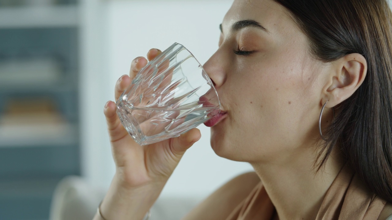 年轻女子喝了一杯水视频素材