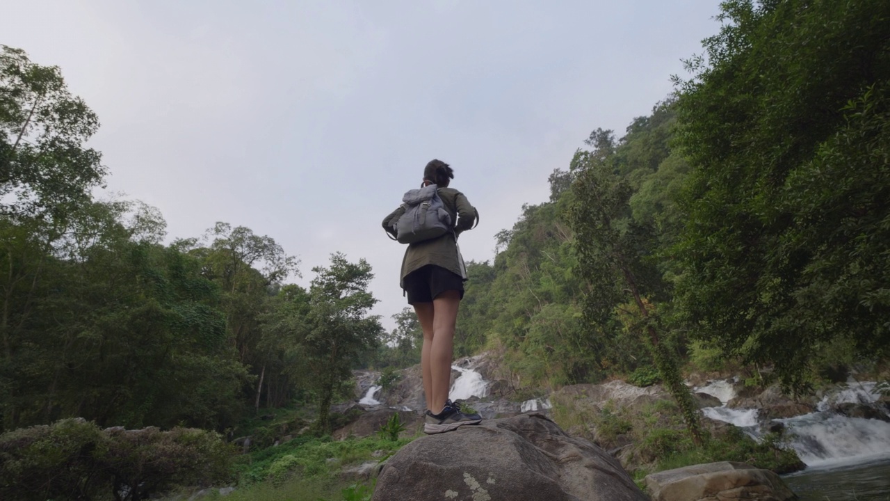 旅行女人与双肩包站在观点热带雨林。视频素材