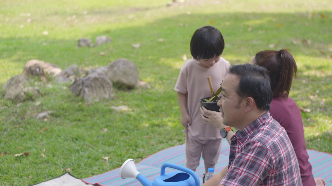 父亲和母亲教他们的两个儿子如何用厨房和花园的垃圾制作有机肥料视频素材