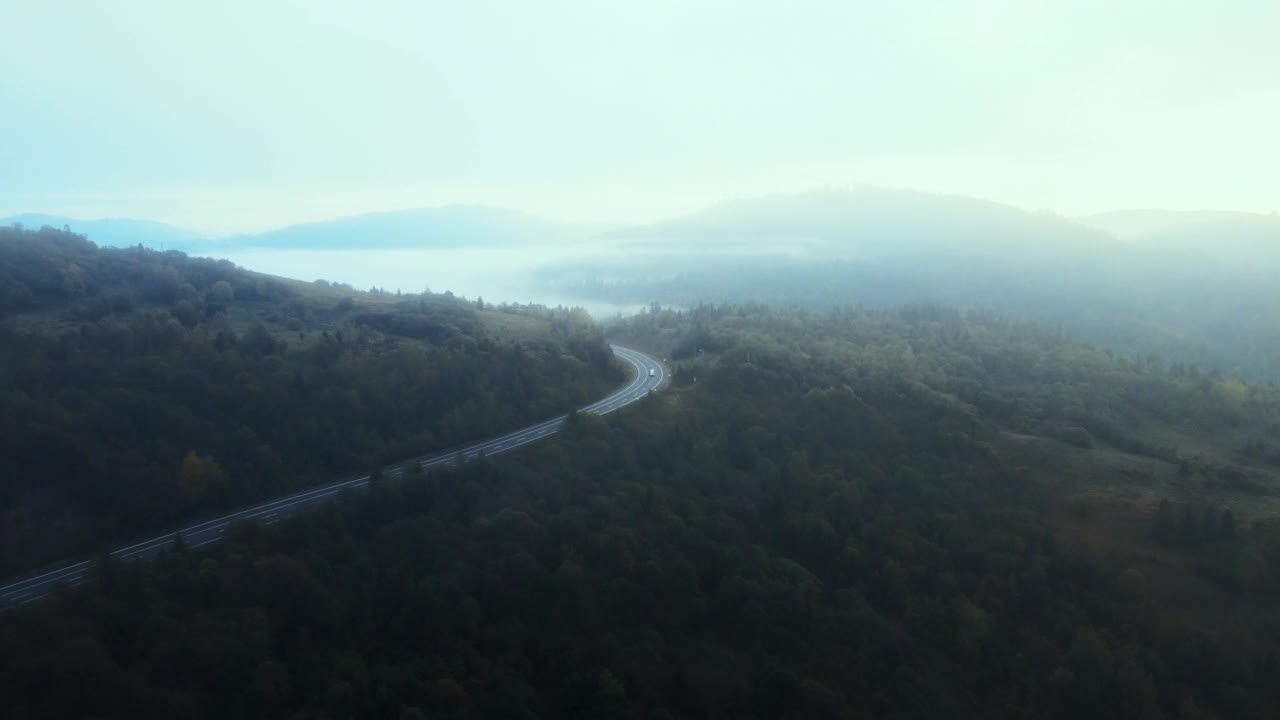 繁忙的高速公路穿过山口。山丘陵与道路在雾中视频素材