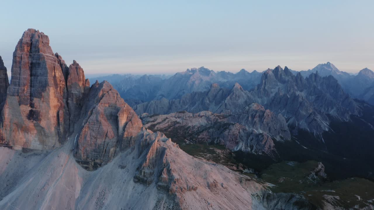 拉瓦雷多高地的无人机航拍。最受欢迎的山在Sexten Dolomites阿尔卑斯山在意大利日落黄昏紫丁香的光。欧洲南蒂罗尔的自然高山公园，史诗般的景观视频素材