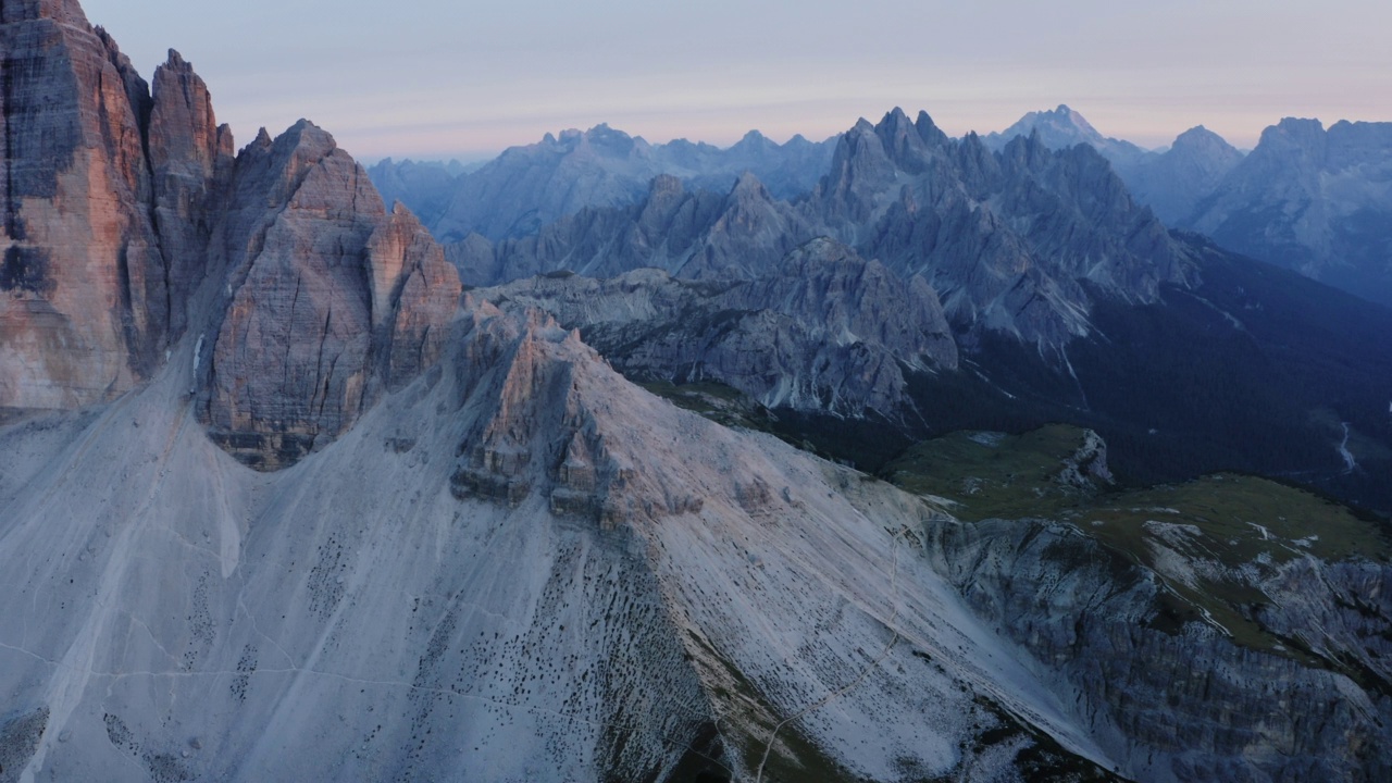 拉瓦雷多高地的无人机航拍。最受欢迎的山在Sexten Dolomites阿尔卑斯山在意大利日落黄昏紫丁香的光。欧洲南蒂罗尔的自然高山公园，史诗般的景观视频素材