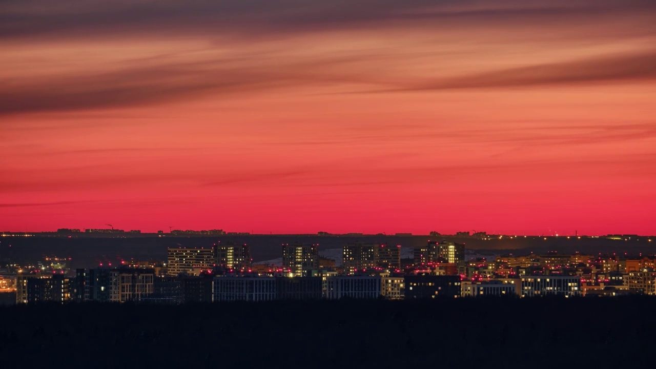 夜晚的城市景观与灯光在城市的房子，时间推移。多层建筑后的夕阳与傍晚的红天空，时间流逝视频素材