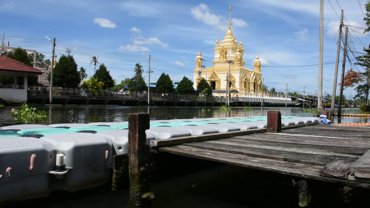 在泰国萨洪海峡的Klong Damnoen Saduak canal和Wat Thammachariya Phirom视频素材