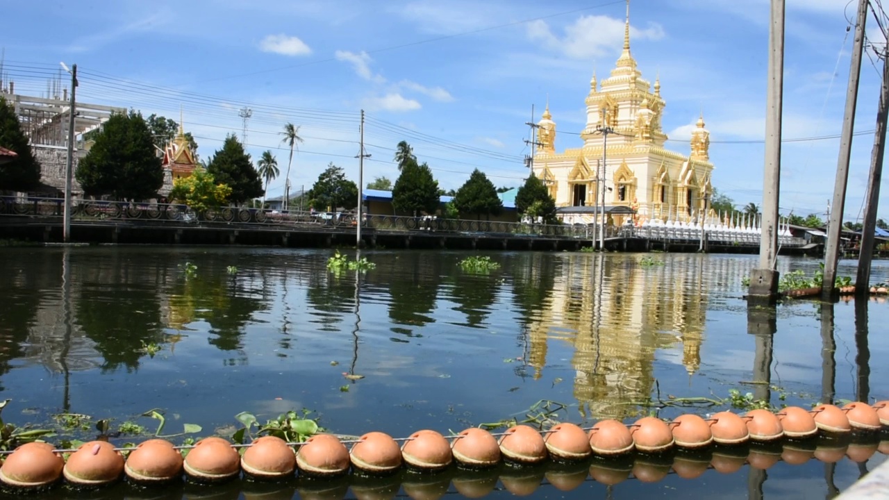 在泰国萨洪海峡的Klong Damnoen Saduak canal和Wat Thammachariya Phirom视频素材