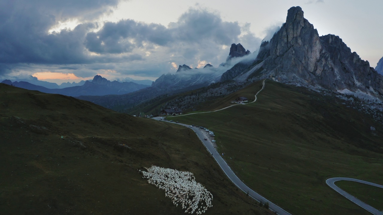 Dolomites山Passo di Giau，在夕阳的Nuvolau gruppe后面的古塞拉山。在草地上放羊。无人机4k镜头视频素材