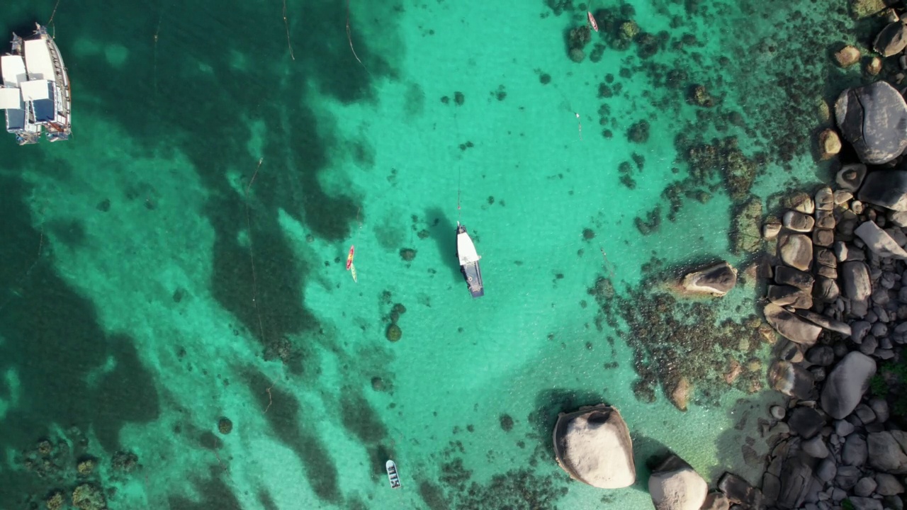 鸟瞰:碧绿的海水随风飘荡，阳光下的海水闪闪发光。许多珊瑚是世界各地潜水者的天堂，夏天的目的地，热带岛屿视频素材