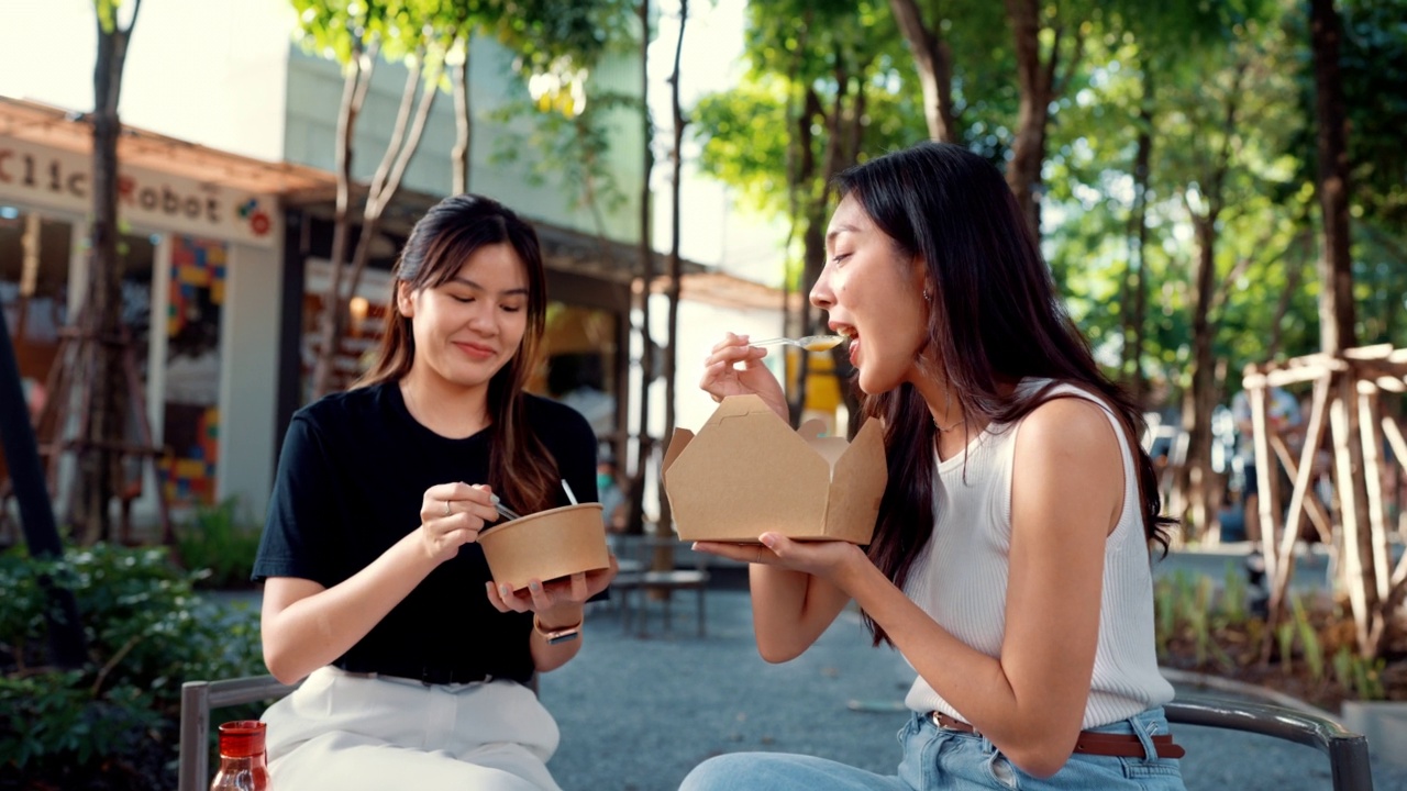 两个美丽的女人在闲暇的时候一起吃午饭。视频素材