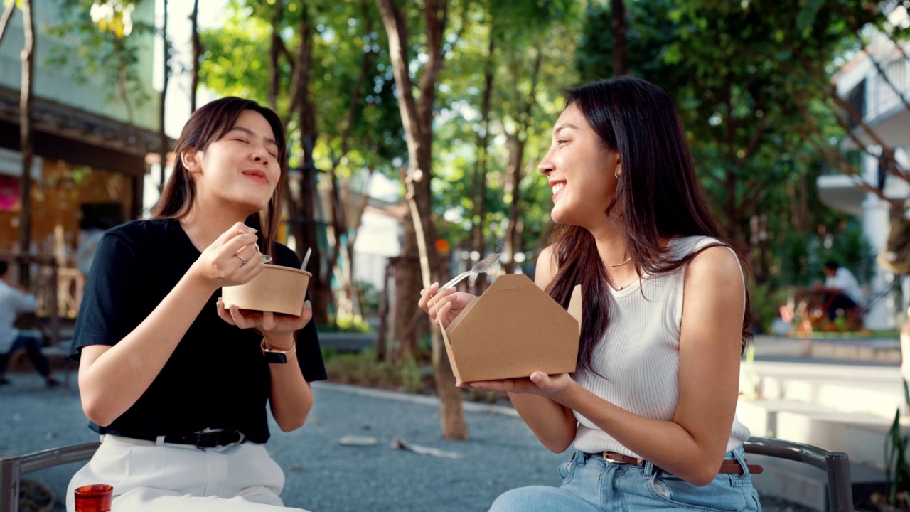 两个美丽的女人在闲暇的时候一起吃午饭。视频素材