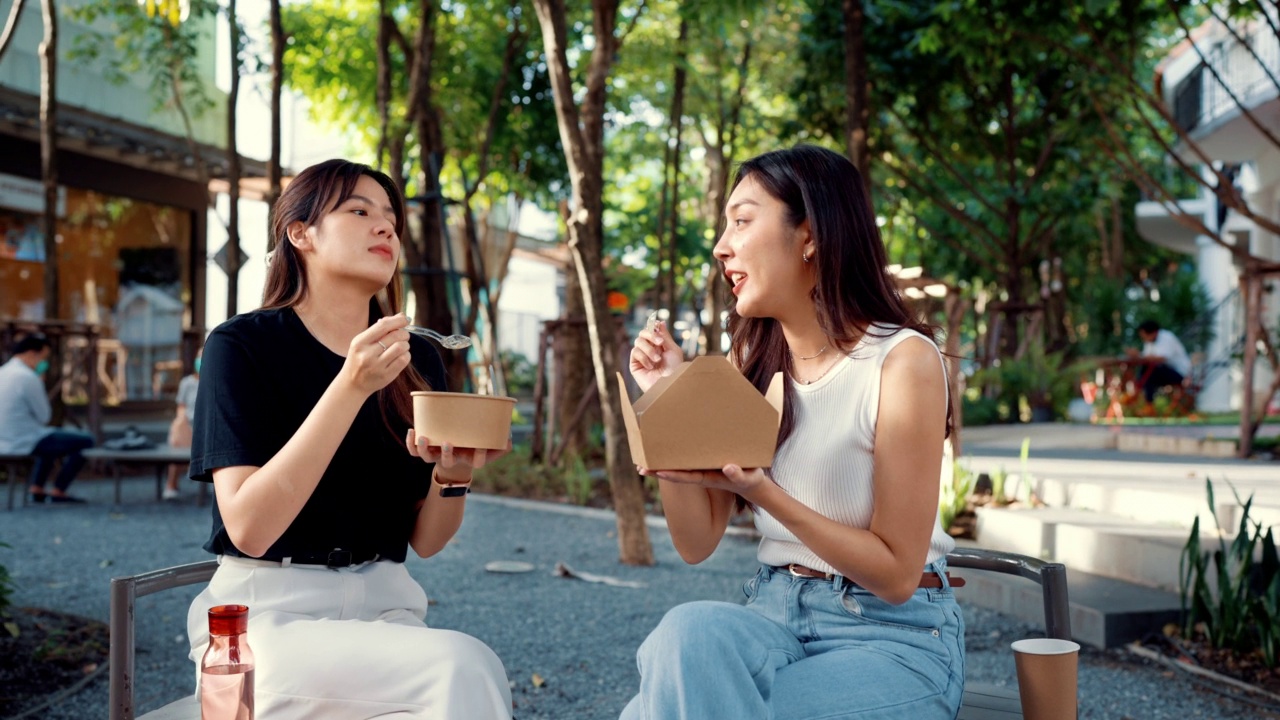 两个美丽的女人在闲暇的时候一起吃午饭。视频素材