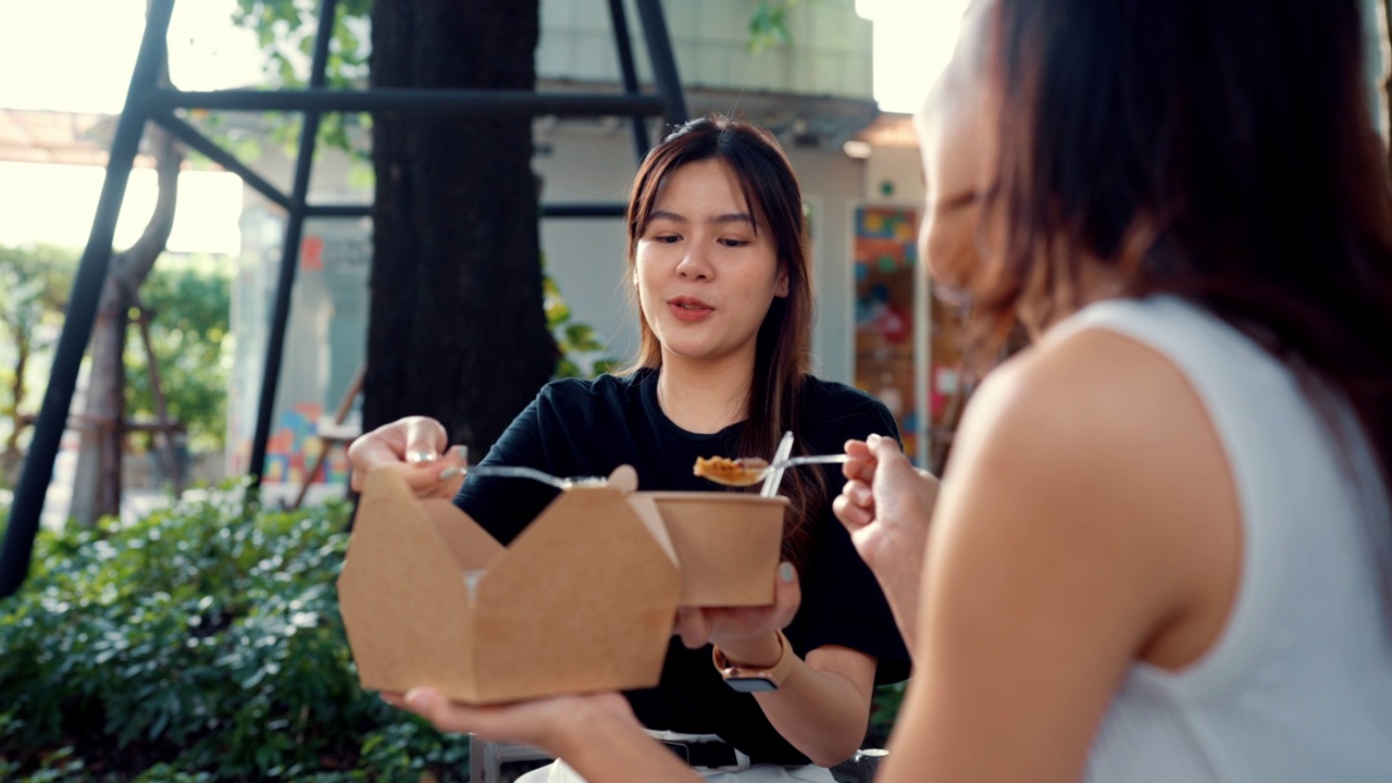 两个美丽的女人在闲暇的时候一起吃午饭。视频素材