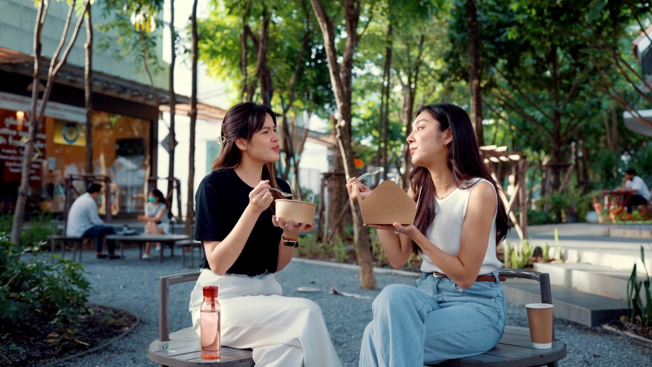 两个美丽的女人在闲暇时间一起吃午饭的肖像。视频素材