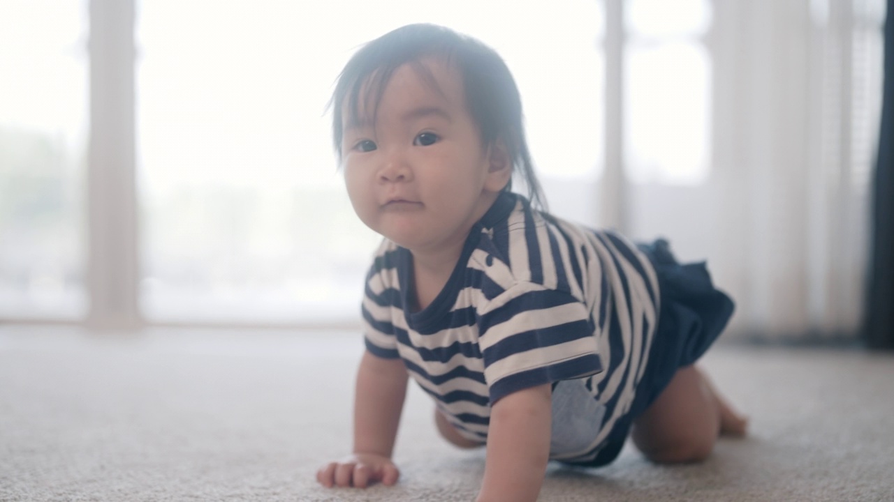 孩子在家里客厅地板上爬来爬去发展技能视频素材