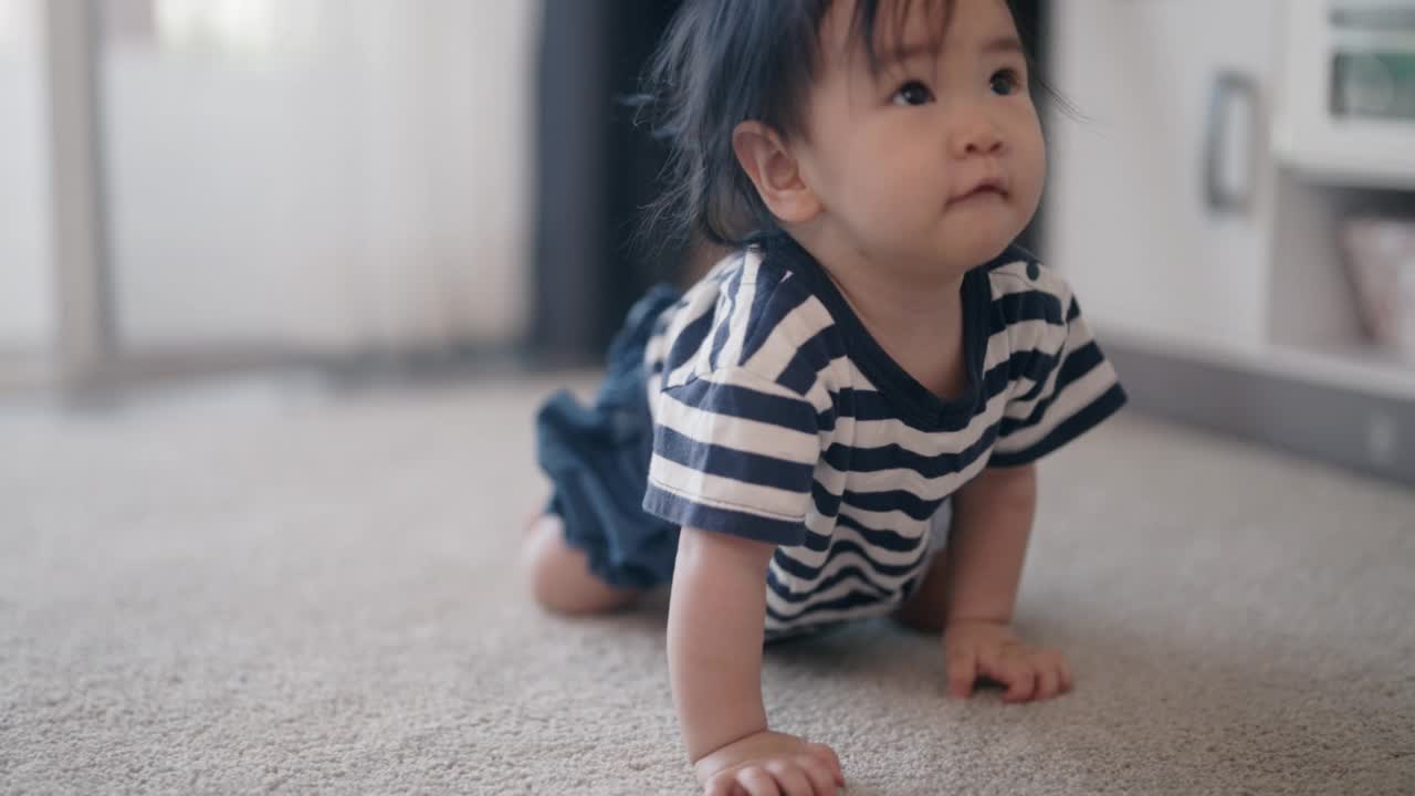 女婴在家里的地板上爬行视频素材