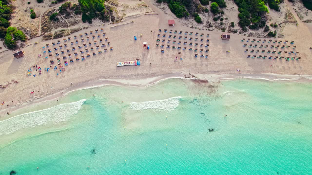 海滩上的伞顶视图，碧蓝的海水和热带的海岸线。视频素材