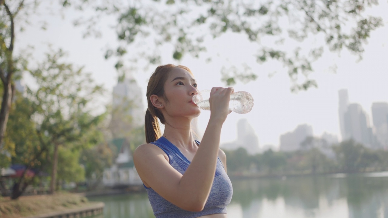 年轻女性在户外运动时喝水视频素材