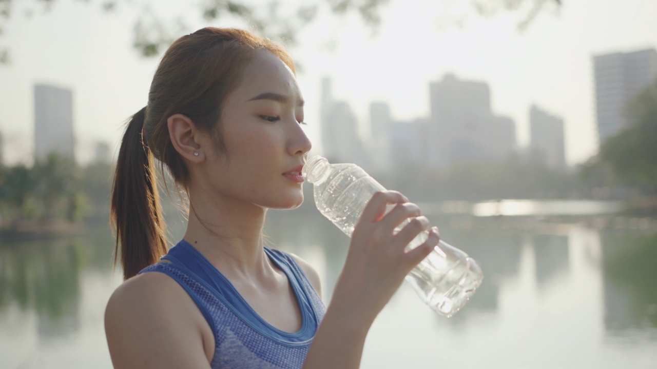 年轻女性在户外运动时喝水视频素材