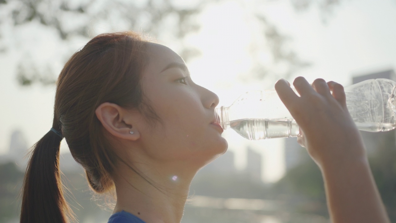 年轻女性在户外运动时喝水视频素材