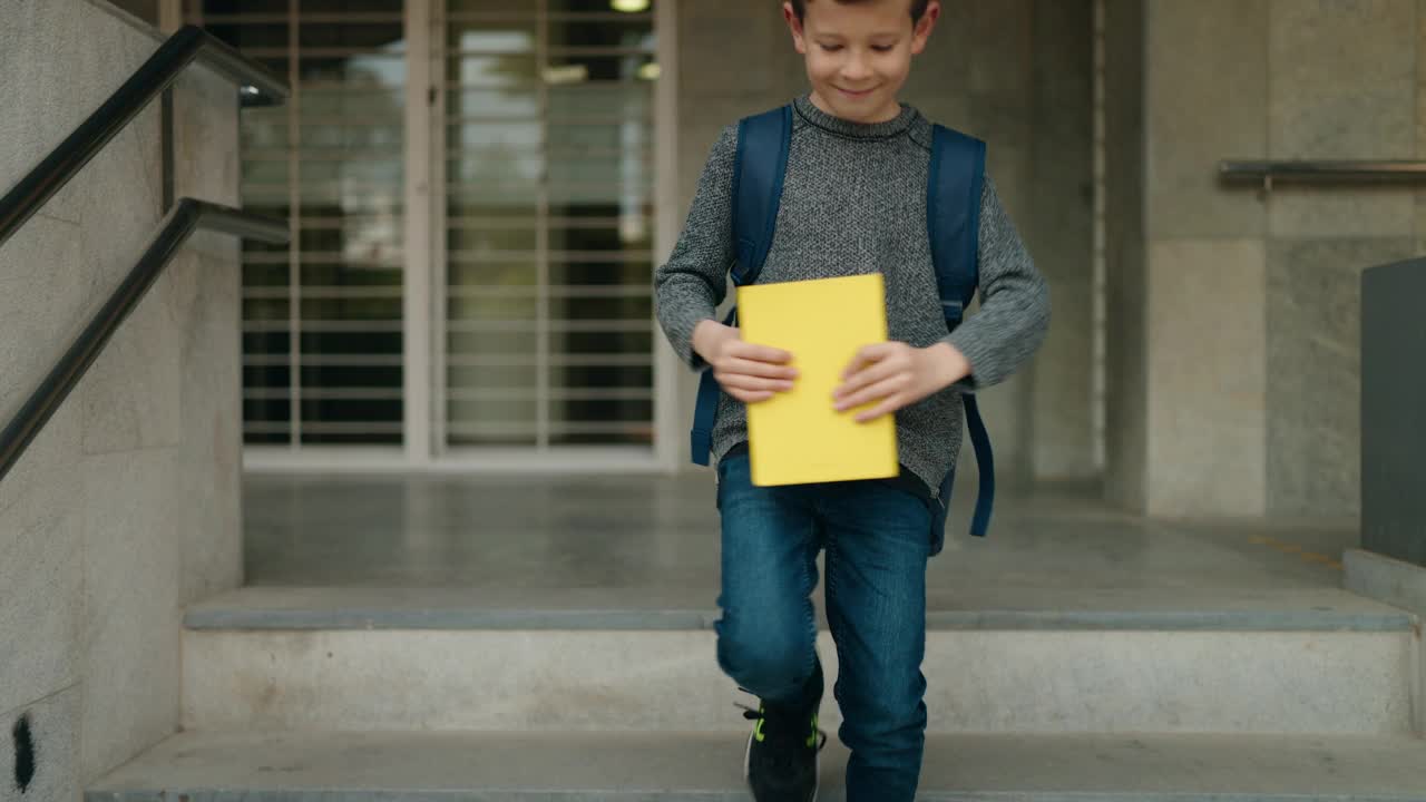 金发碧眼的学生坐在学校楼梯上看书视频素材