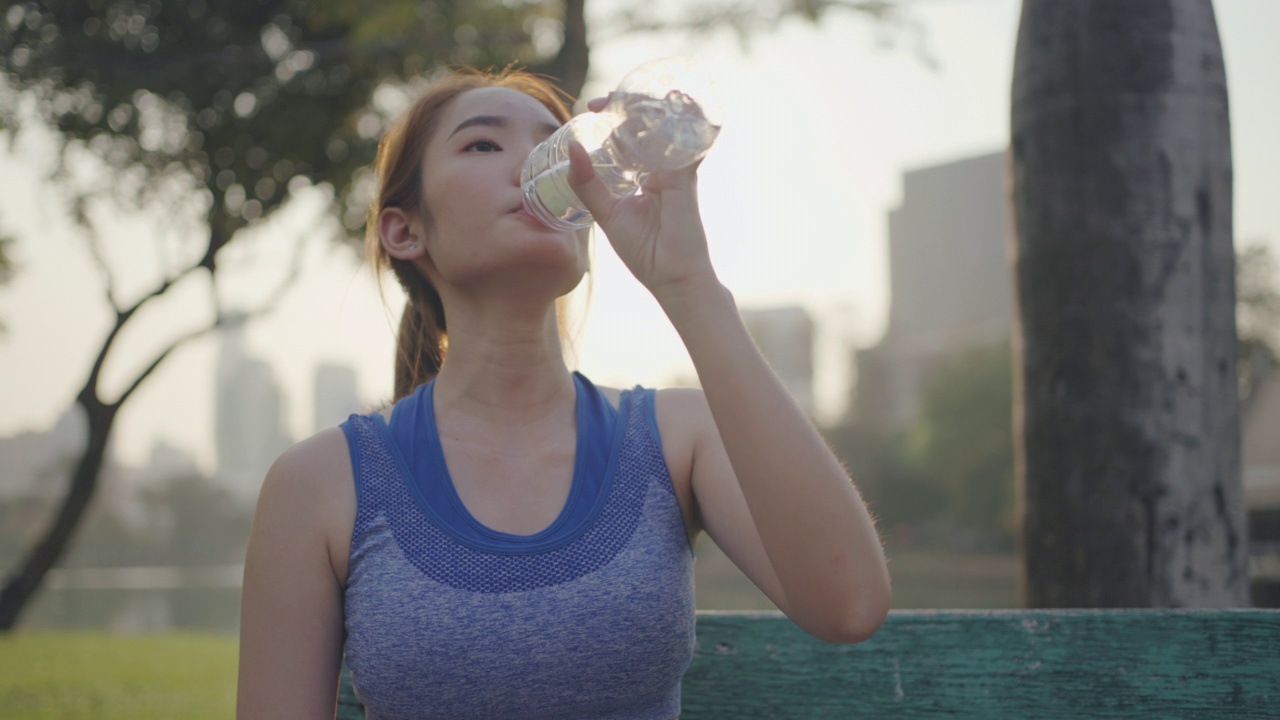 年轻女性在户外运动时喝水视频素材