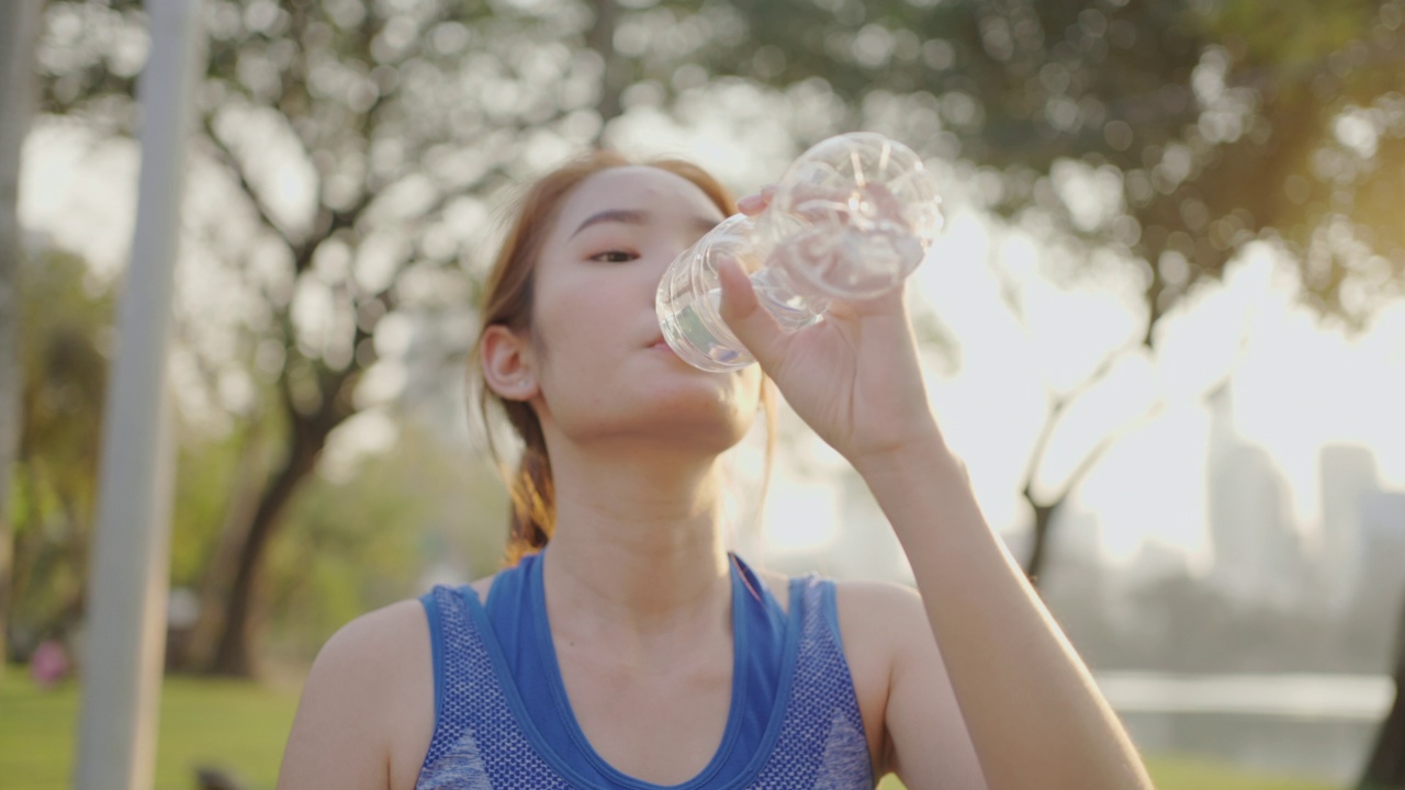 年轻女性在户外运动时喝水视频素材