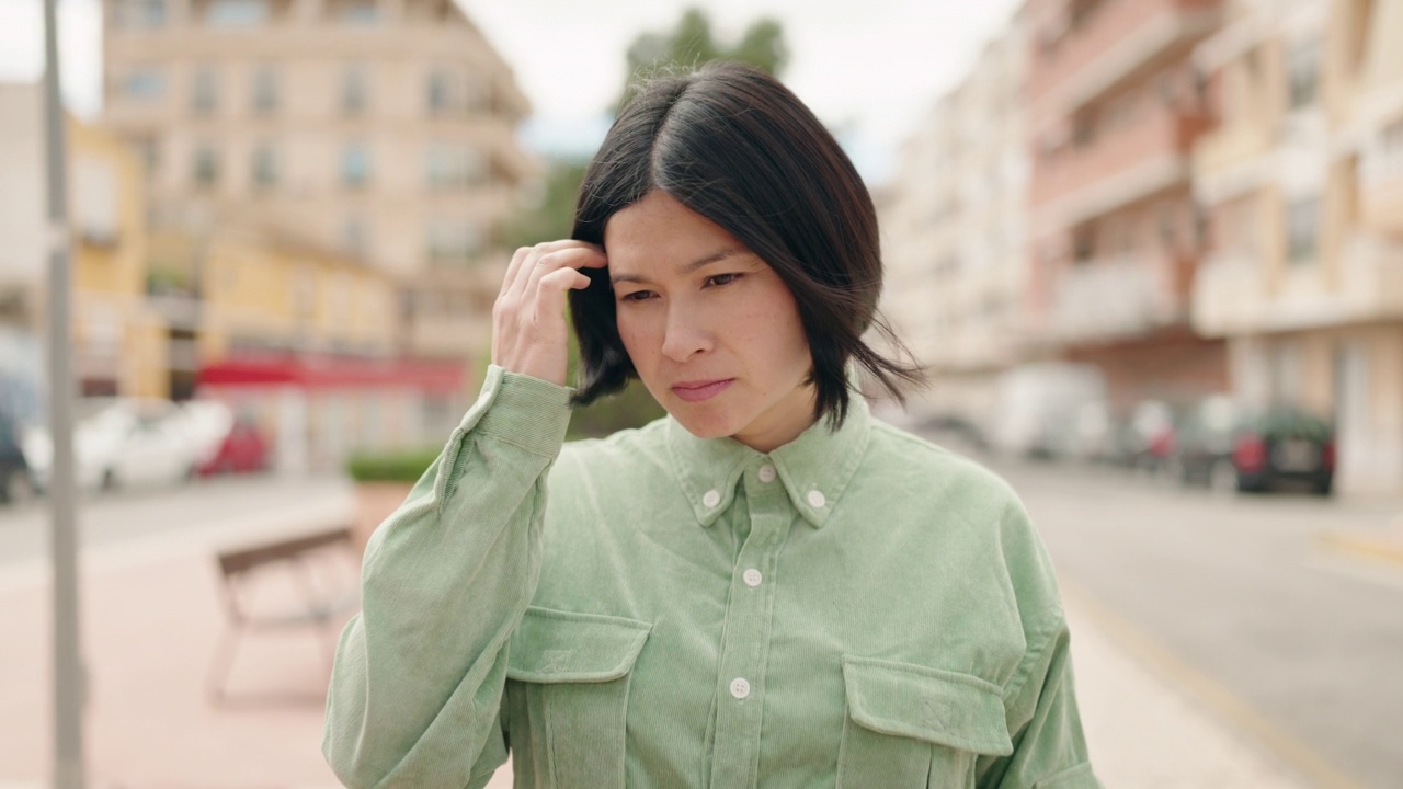 表情轻松的年轻中国女子站在街上视频素材