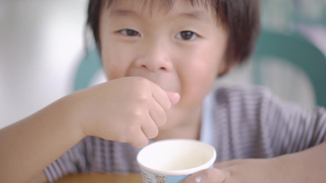 亚洲男孩在自助餐厅吃冰淇淋视频素材