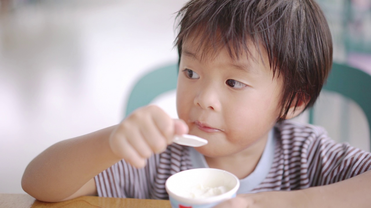 亚洲男孩在自助餐厅吃冰淇淋视频素材