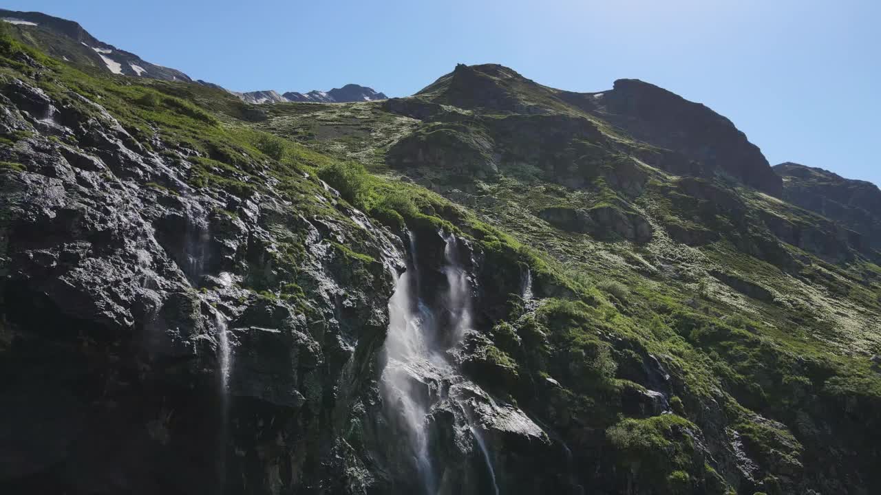 水顺着山坡流下，从一块巨大的岩石上溅落下来视频素材