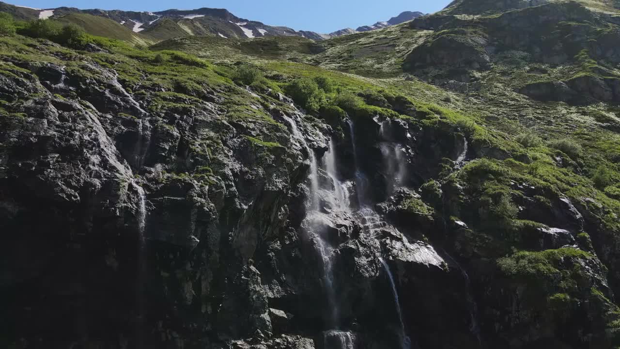 水顺着山坡流下，从一块巨大的岩石上溅落下来视频素材