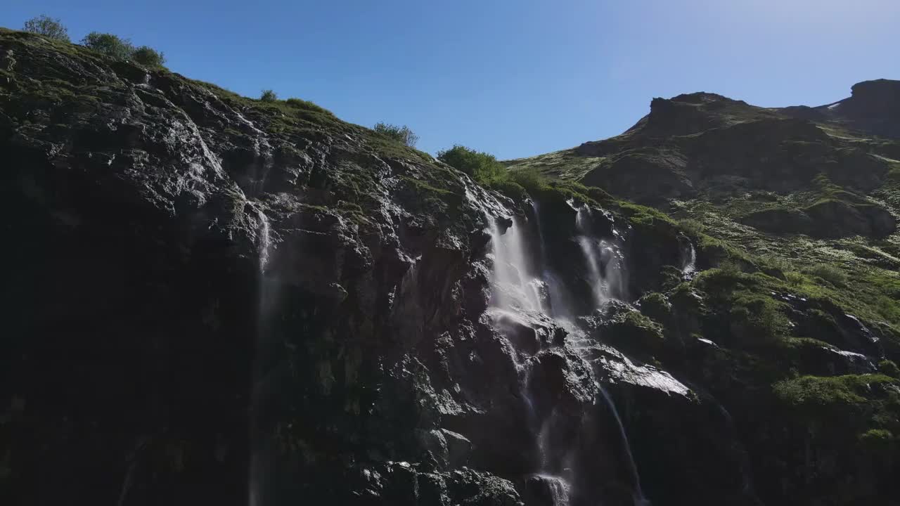 水顺着山坡流下，从一块巨大的岩石上溅落下来视频素材