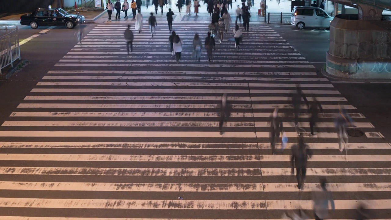 4K延时拍摄人们穿过街道在日本，夜晚的时间很长。视频素材