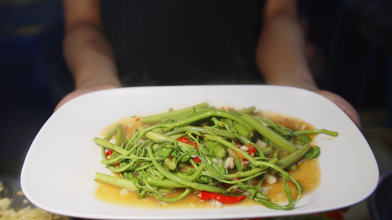 近距离烹饪美味健康的蔬菜炒制新鲜的绿色辛辣水含羞草在厨房，泰国美食视频素材