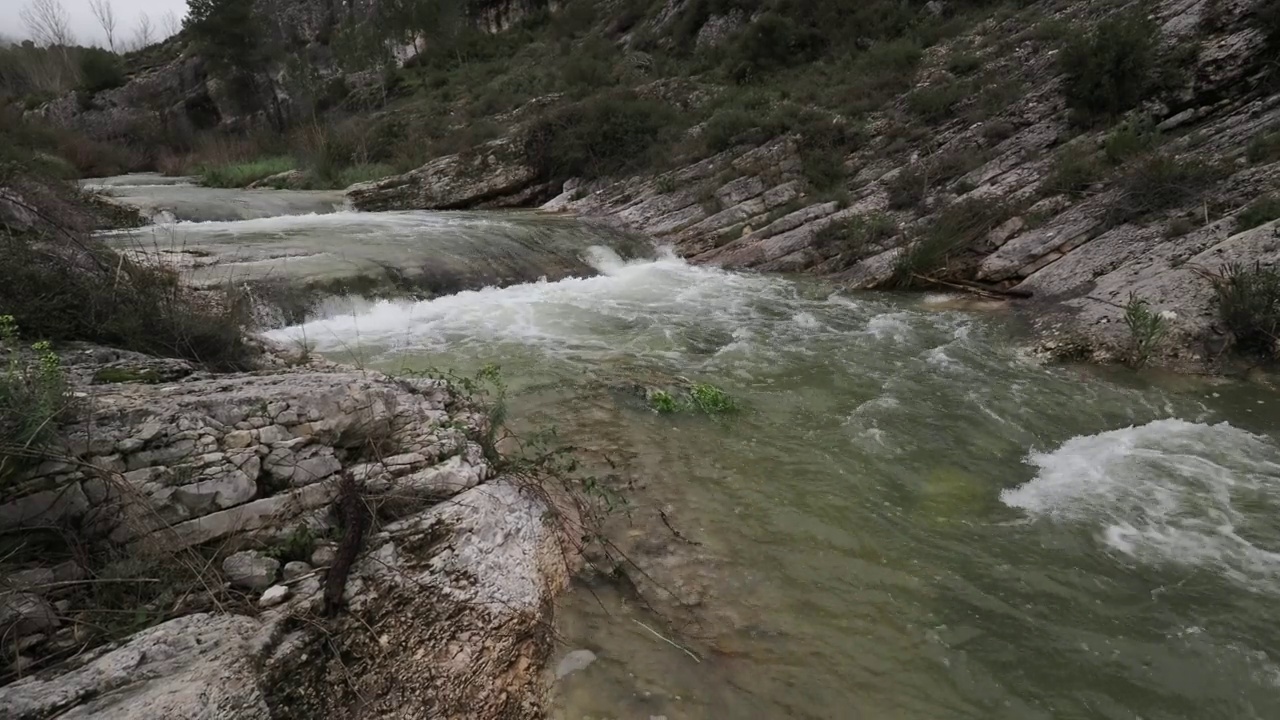 山川河水湍急，水流清澈。鸟瞰，山涧间有河流，春天有大瀑布。视频素材