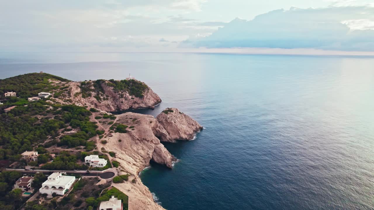 在岩石嶙峋的海岸线上，从上面俯瞰日出时的灯塔风景。视频素材