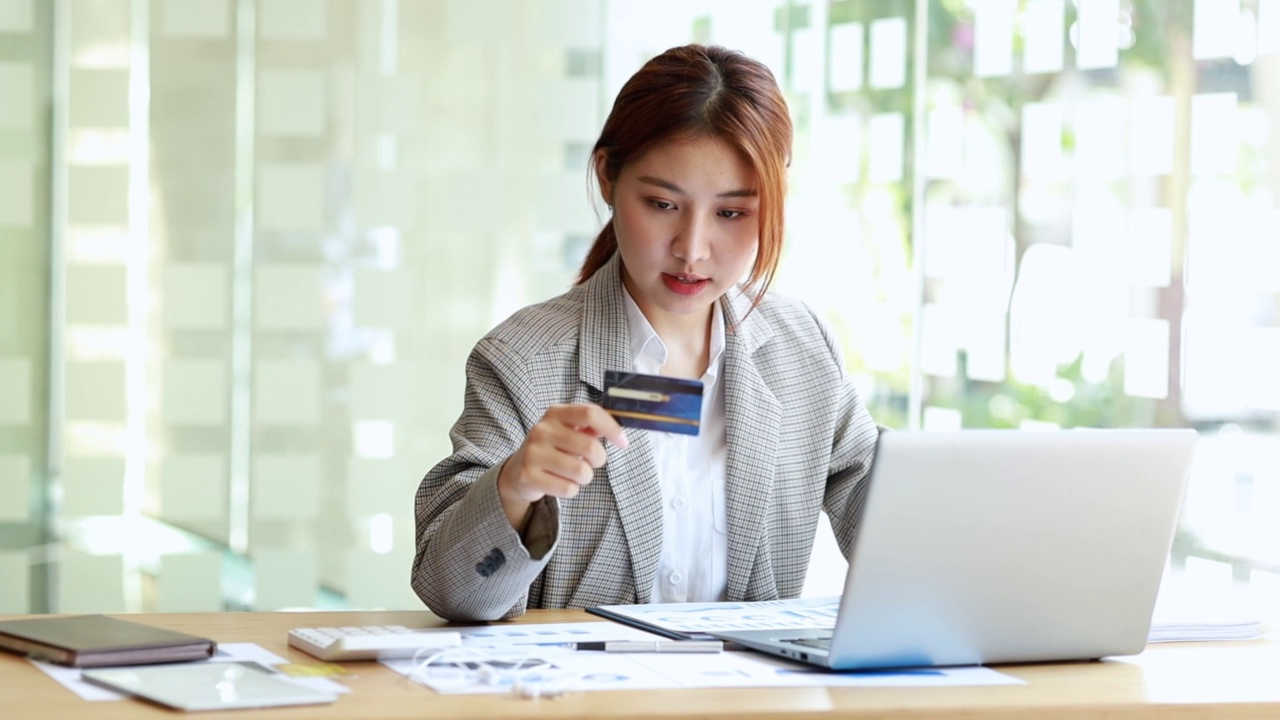 美女手里拿着信用卡，她用信用卡在网上购买商品和服务，用信用卡网购的概念，在网站上订购商品和服务。视频素材