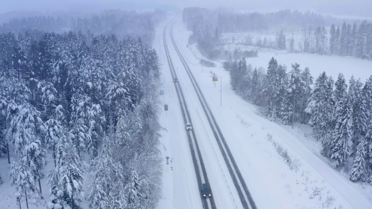 许多汽车行驶在冬季的高速公路上，森林，田野，没有太阳，大雪，典型的冬季天气视频下载