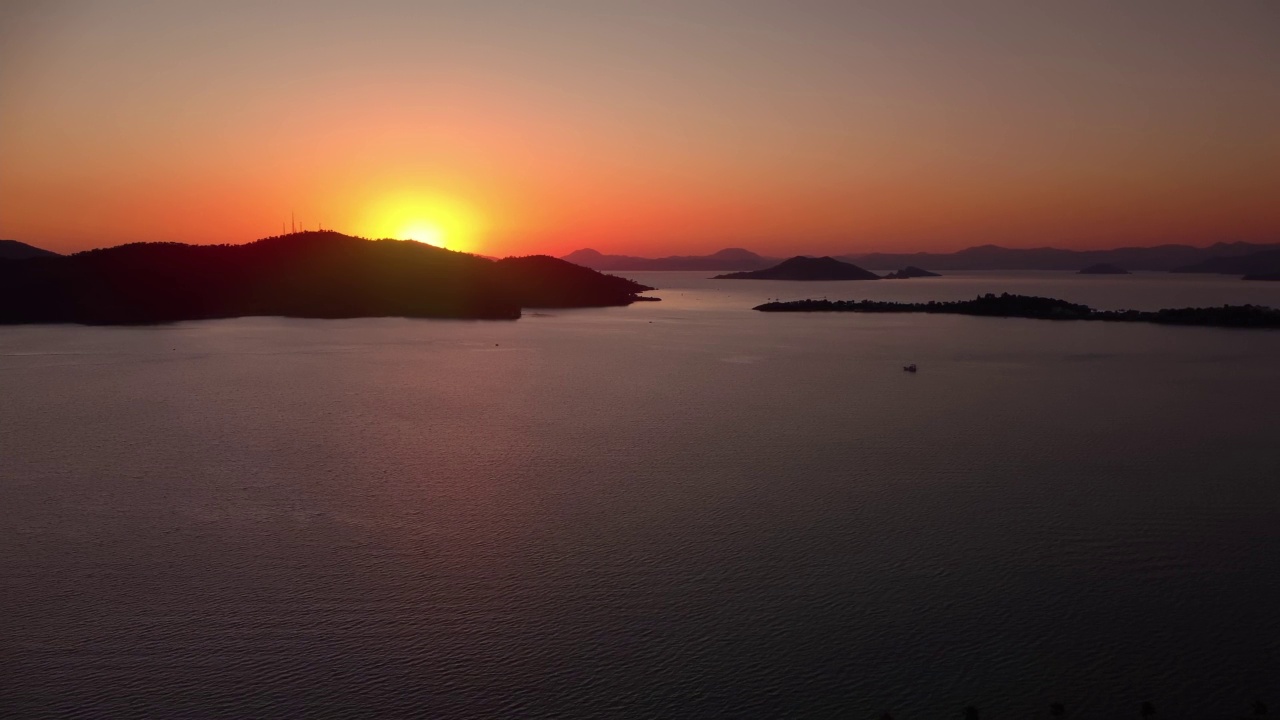 在平静的夏季傍晚，无人机拍摄的山海日落景观视频素材