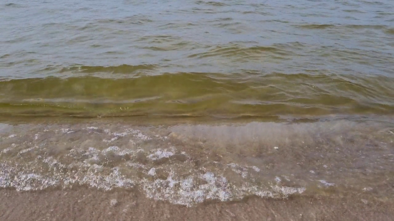 波浪翻滚在沙滩上。夏天游泳的季节视频素材