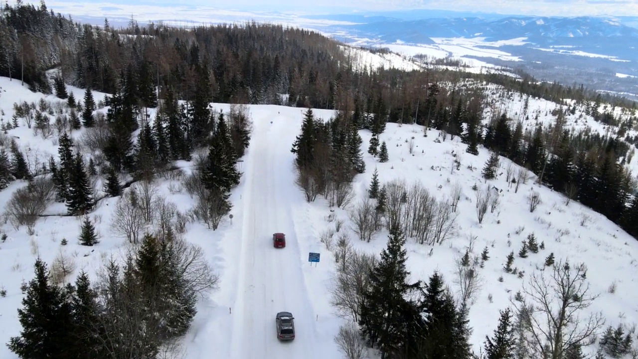 汽车在雪山公路上行驶的鸟瞰图视频素材