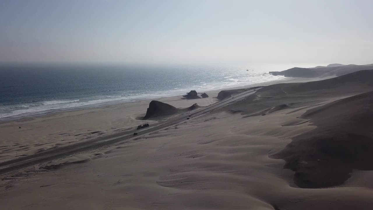 无人机拍摄的公路在处女地沙漠与沙丘和大海视频素材