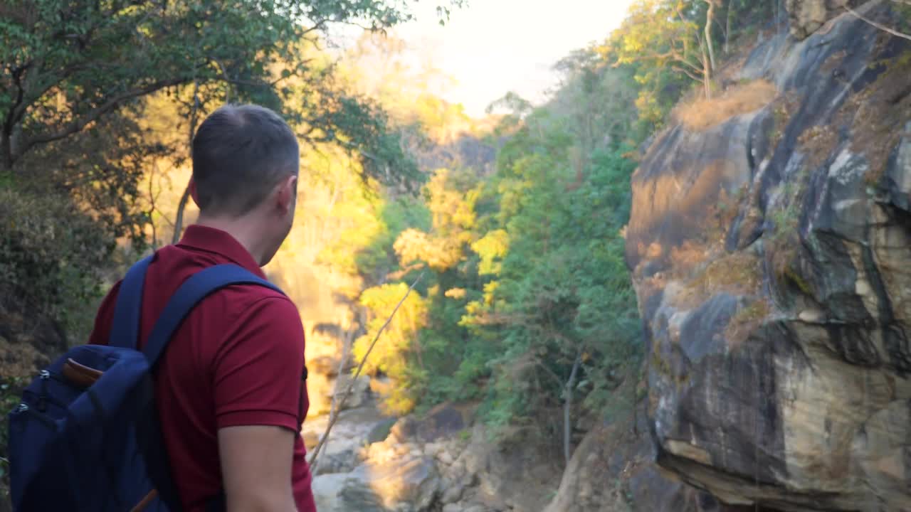 背着背包庆祝到达山顶的快乐旅行者。年轻人在山里旅行。徒步者胜利地举起双臂，欣喜地成功地举起双手。积极的生活方式，旅游理念视频素材