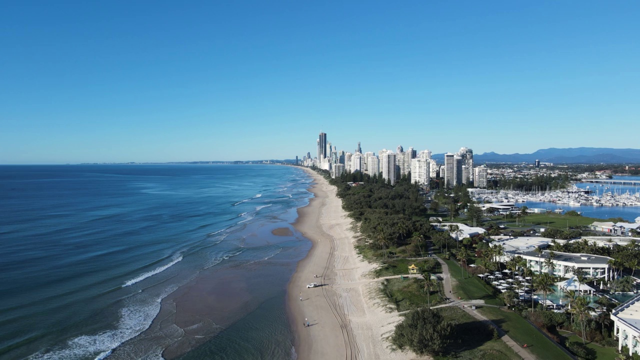 沿海绿色走廊沿着沿海地带延伸，靠近高耸的城市扩张。无人机的观点视频素材