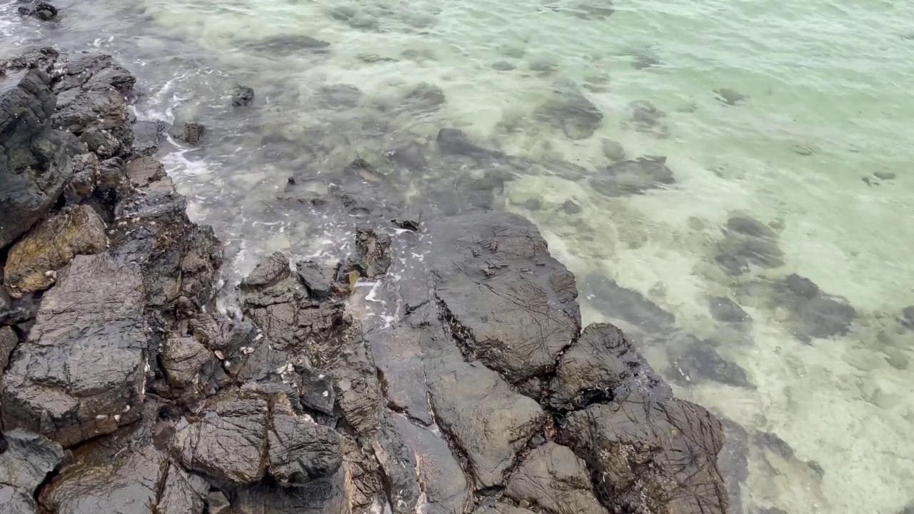 海浪冲击着布满岩石的海岸线。阳光明媚的白天海景。暑假的热带海滩。视频素材