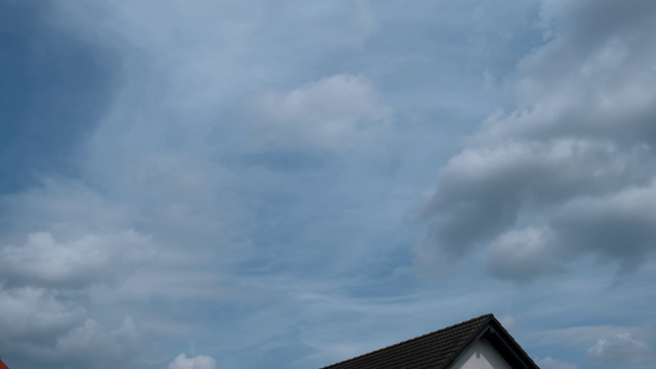 时间流逝。下雨前，一幢公寓楼的屋顶上飘着云朵。视频素材