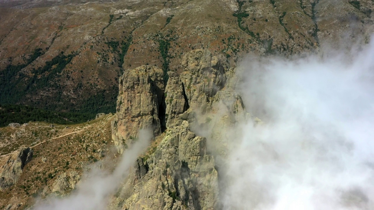 空中拍摄的云在自然岩层上移动- Aiguilles de Bavella，法国视频素材