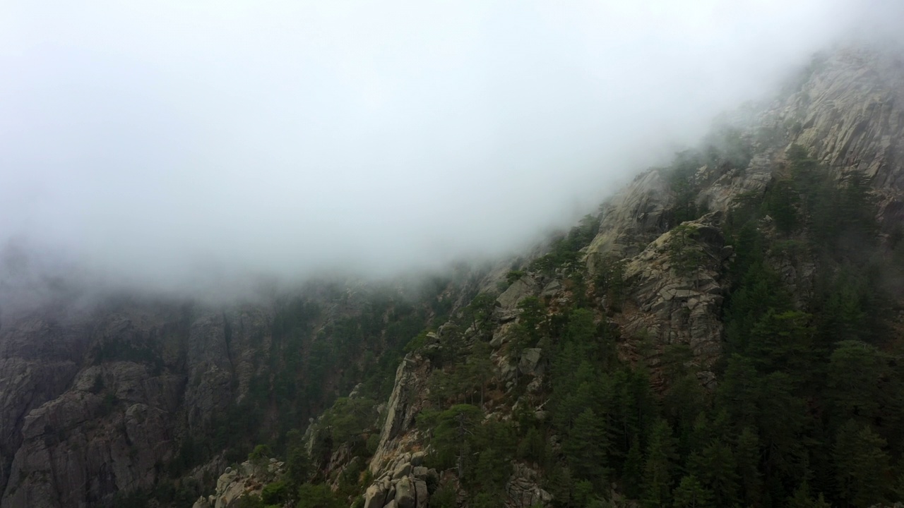 空中向前拍摄的戏剧性的云移动的岩层- Aiguilles de Bavella，法国视频素材