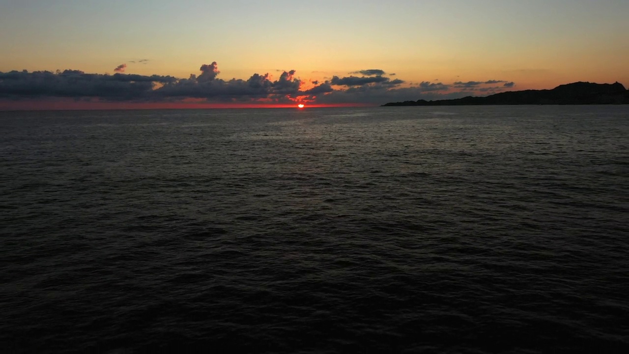 在法国博尼法西奥的日落期间，向后和向上的宁静海洋的空中风景拍摄视频素材